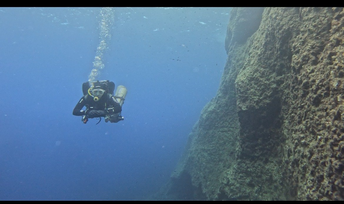 Adam hovering beside a reef wall at Cirkewwa, Malta